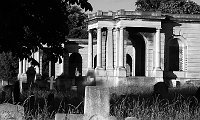 Brompton Cemetery in B&W II  One day on my walk home from the tube station to my flat, I noticed hundreds of people turning into this cemetery (including roller bladders, bicyclists, skateboarders, and joggers). Mighty happy cemetery if you ask me! So I got out the map and found two things. First, the main path through the cemetery is quite a shortcut between two major roads. Two, people in London will take advantage of 'green space' no matter how many dead people were there first! Turns out this cemetery has been used in several movies (The Wisdom of Crocodiles, Crush, and and Johnny English). It wasn't opened until 1840, which explains why I couldn't find any really old tombstones. Still, I thought it was rather photogenic. The big crosses and statues packed so closely together with mausoleums encircling them just caught my attention. So I took this series of photos. I don't think this struck my fancy based on my dour mood from the frustrating proposal I was working on -- but you be the judge. Interesting or depressing??